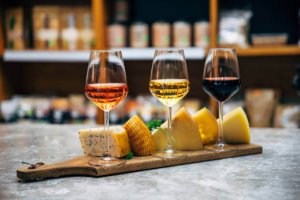 Wine bottles, glasses and cheese in restaurant